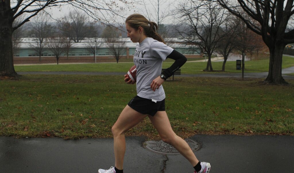 Young woman running in a park with black shorts and grey t-shirt on a dreary day