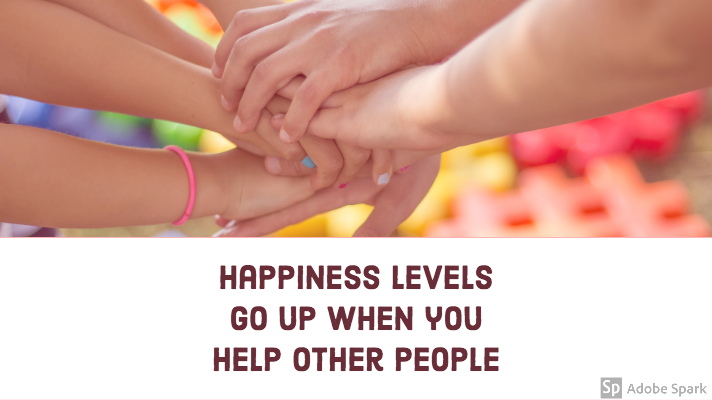 Close up of a pile of hands on top of each other. Quote underneath says "Happiness levels go up when you help other people"