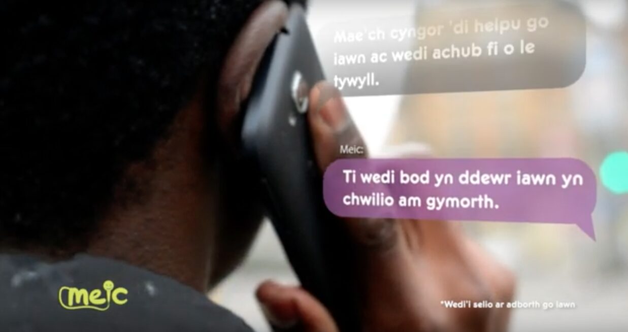 Llun o'r cefn o rhywun yn dal ffôn i'r clust, mae yna destun wrth ochr y person yn dweud "Ti wedi bod yn ddewr yn chwilio am gymorth"