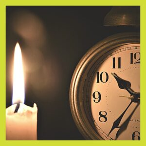 Old fashioned alarm clock in candlelight