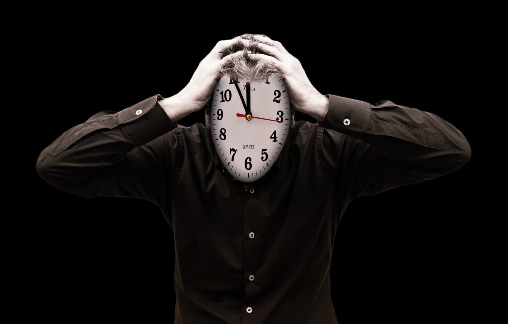 Person with head in hands, face is replaced with a clock face
