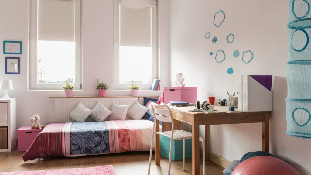 A young girls bedroom, with a bed, desk and chair
