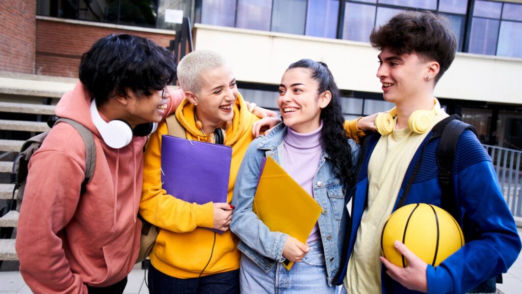 Group of 4 friends huddled around each other hugging