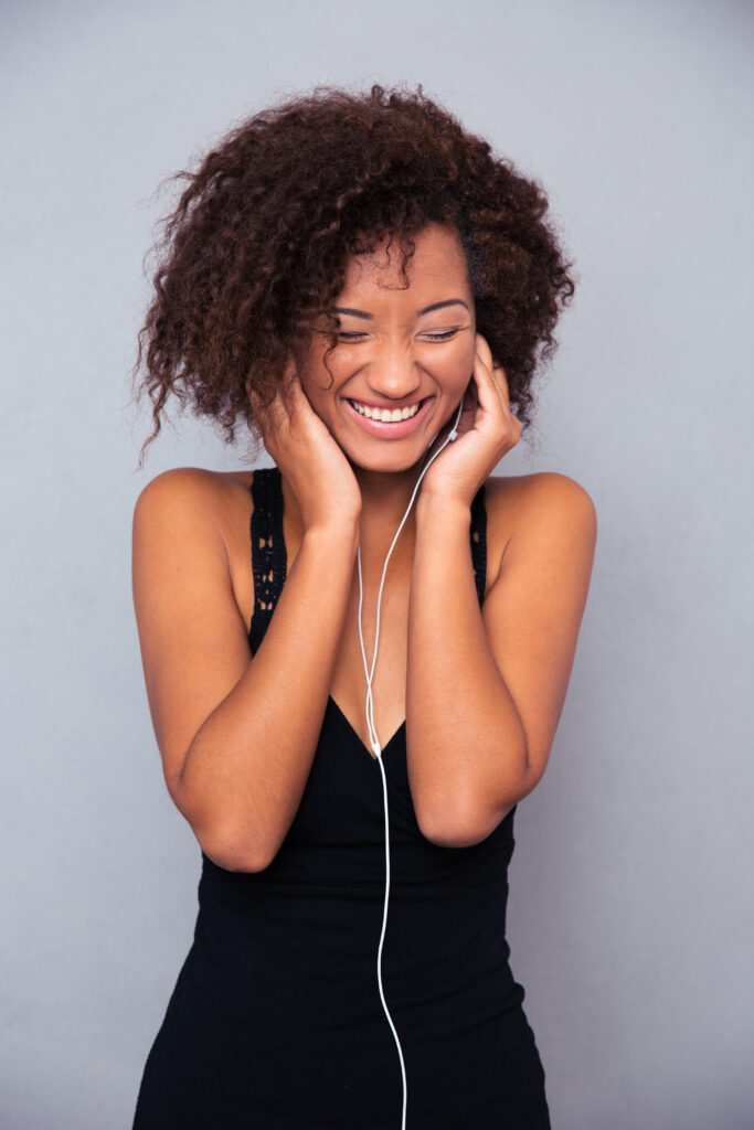 Smiling happy young woman listening to something on her earbuds.
