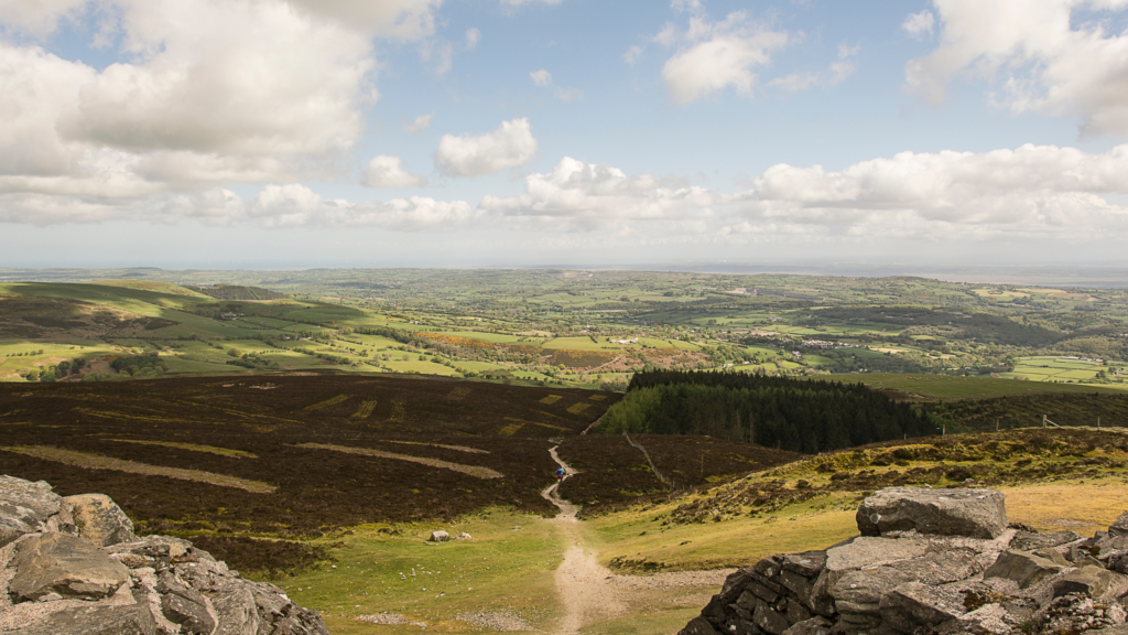 Aerial view of a valley, with rolling grassy green fields