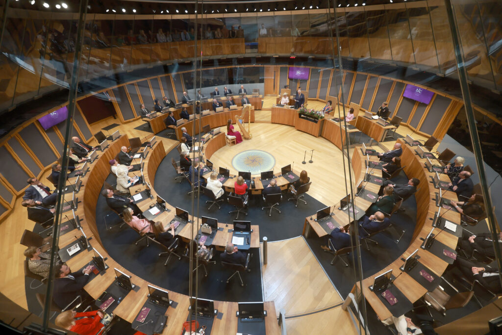 An aerial photograph of the chamber in the Senedd building, full on ministers sat at their desks. 