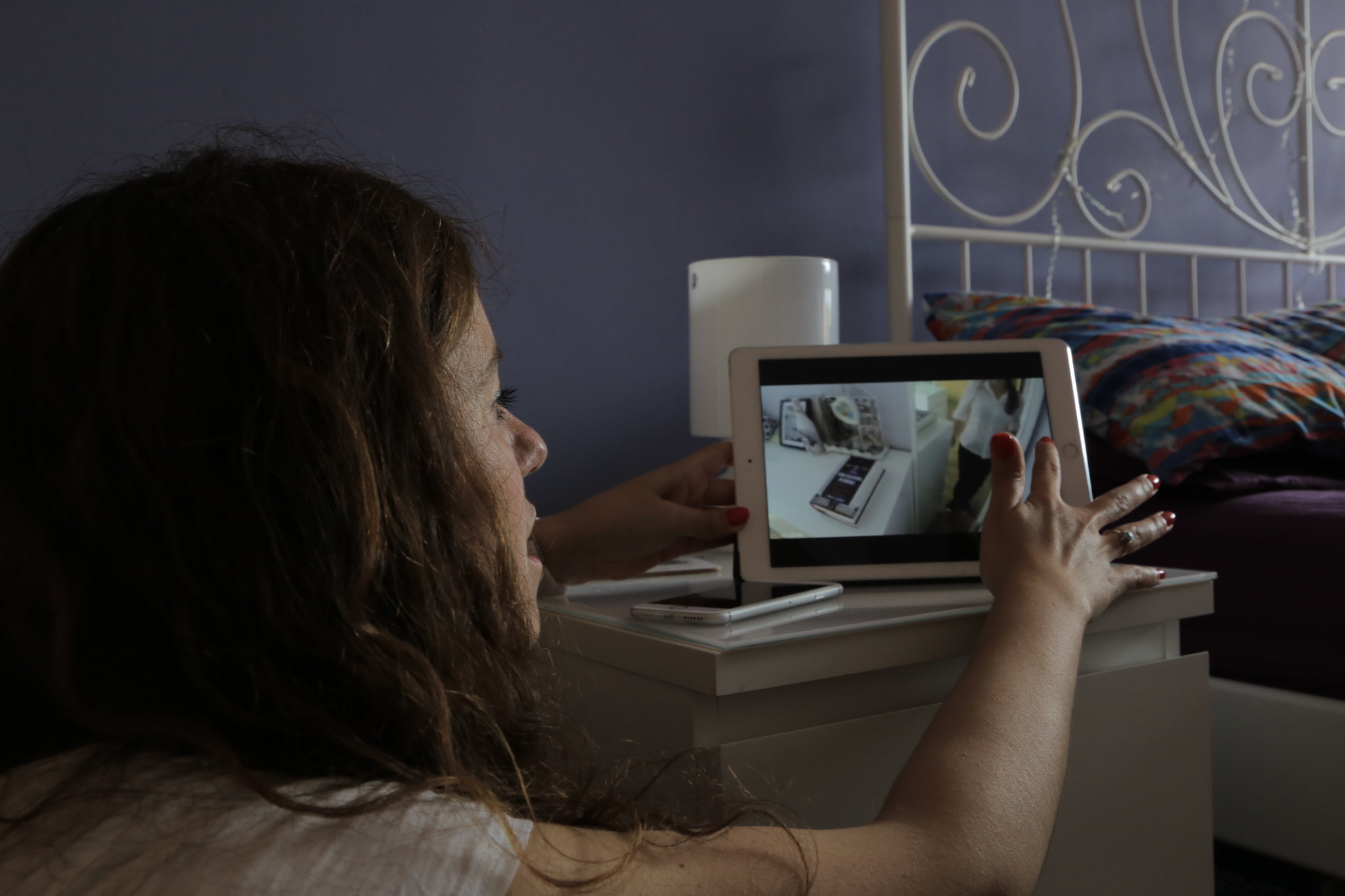 A young woman pointing and showing a video on an ipad