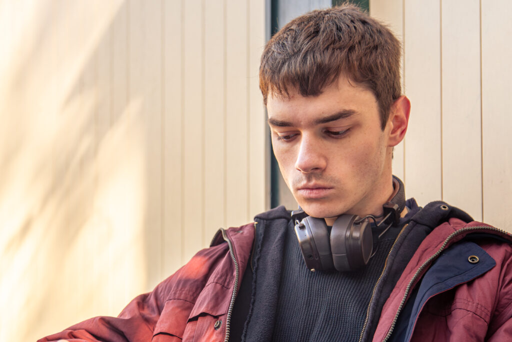 a young boy wearing headphones looking stressed and worried