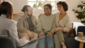 Teen girl in care sitting with foster family on sofa