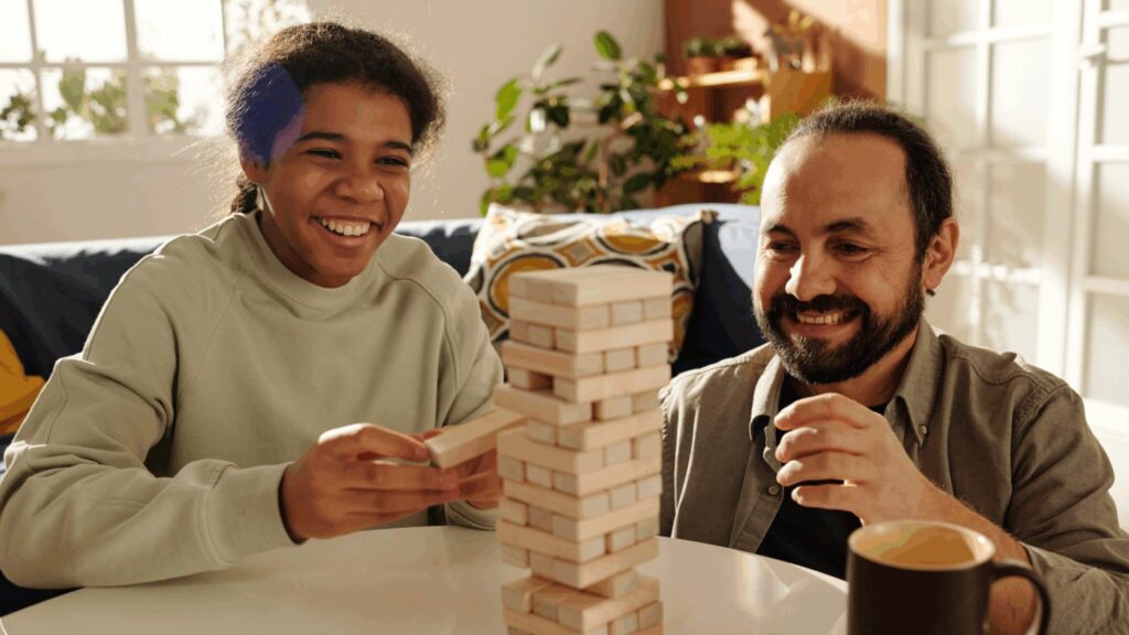Foster dad playing jenga with teen girl in care