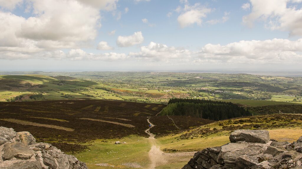 Aerial view of a valley, with rolling grassy green fields