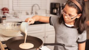 Teen girl making pancakes