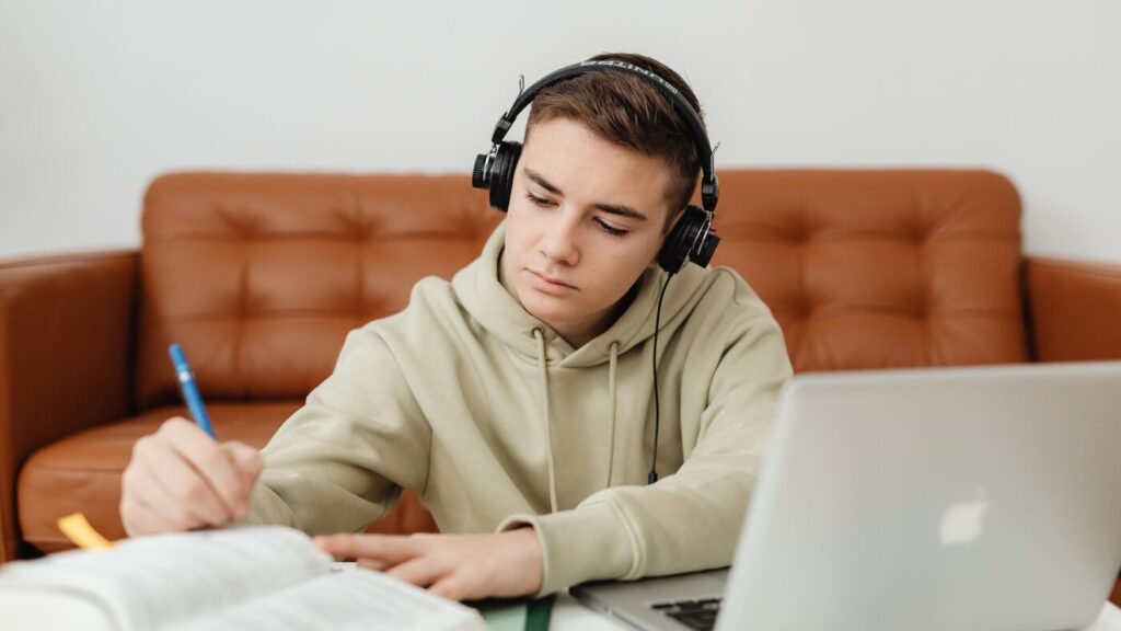 Teen boy revising with headphones on