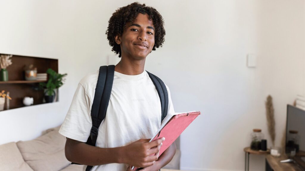 Young adult with a rucksack and a folder in his hands