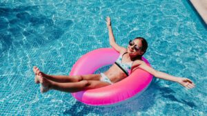 Teen girl floating in an inflatable ring donut on a pool