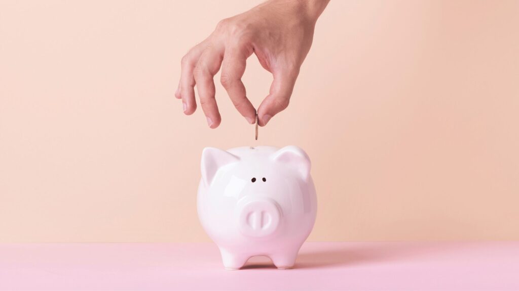 Person putting money into a piggy bank