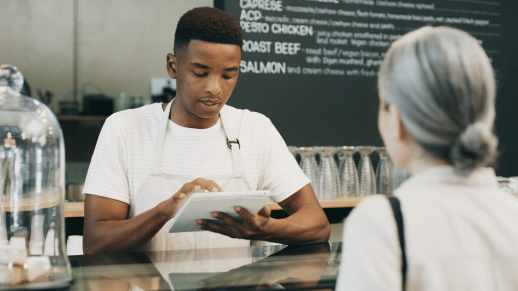 Teen working in a cafe taking an order