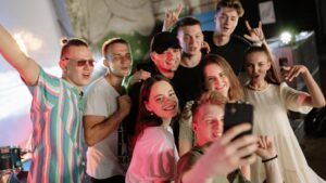 Groups of teens posing for a group photo at a festival
