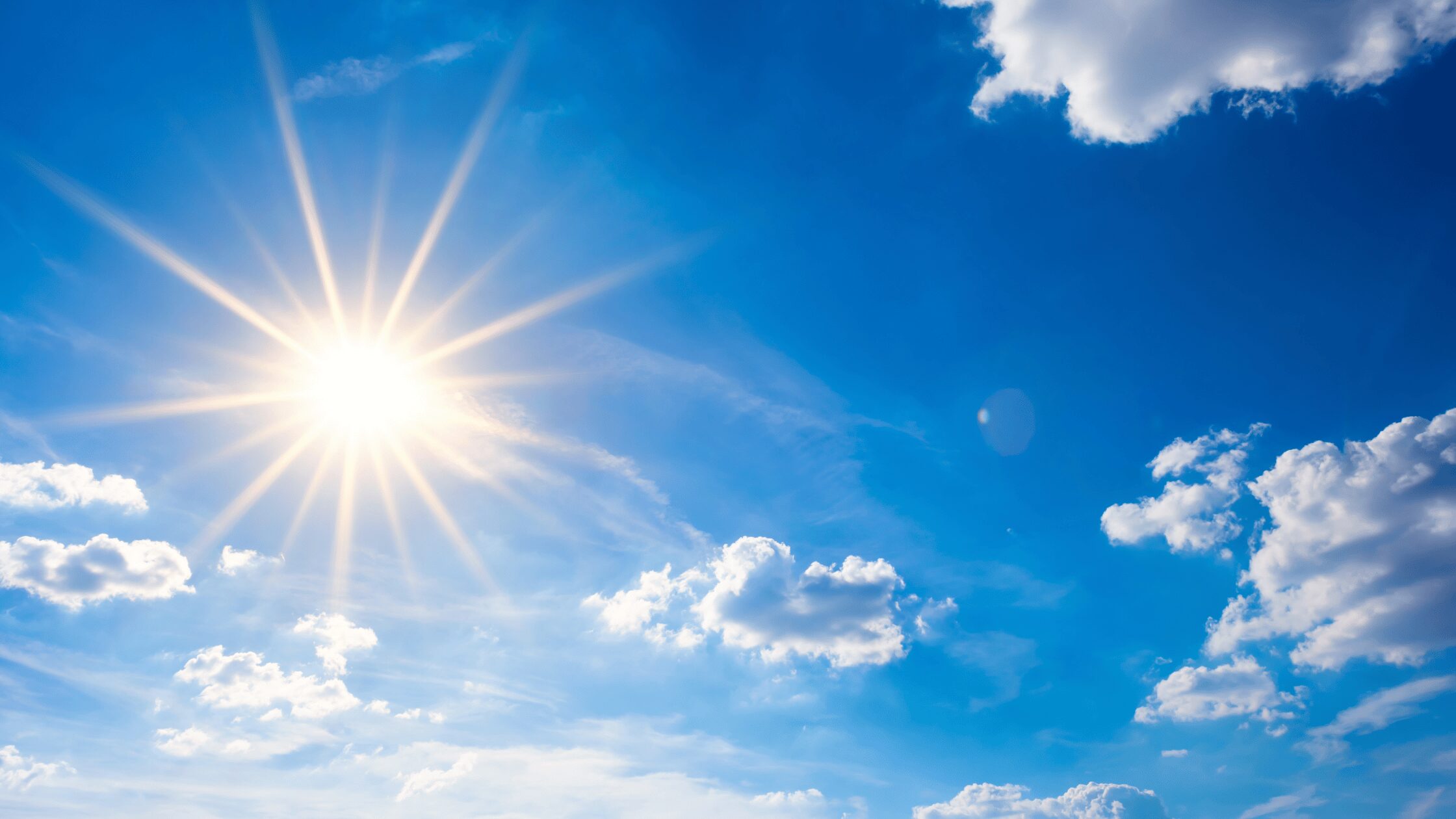 Sun glaring out from a blue sky