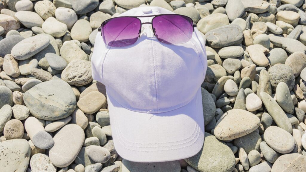 Sunhat and sunglasses on pebble beach